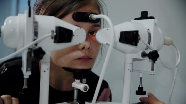 Den ögonläkare undersöker de unga patienterna öga och sedan tittar in i kameran. Närbild — Stockvideo