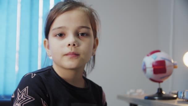 Młoda dziewczyna w recepcji okulisty, sprawdza wzrok — Wideo stockowe