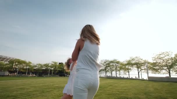어느 화창 한 날, 공원에서 어머니와 딸이 걷고 있는 모습 — 비디오