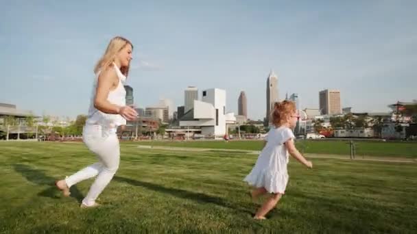 在阳光灿烂的日子里，妈妈和女儿在公园里赛跑 — 图库视频影像