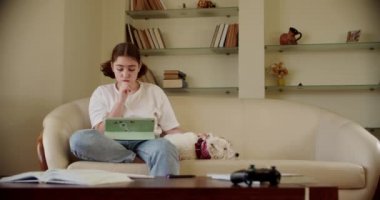 İnternet dersinde dijital tablet teknolojisi kullanan bir kız tabletle video konuşuyor. Geniş görünüm görüntüleri