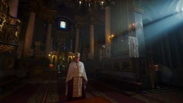 The priest stands in the middle of the Orthodox Church, in the rays of light. Ivano 28 October 2021. Ukraina — стоковое видео