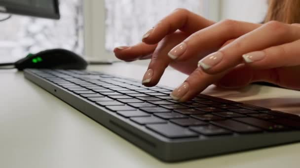 여자 손 이 마우스를 스크롤하고 컴퓨터 책상 위에 키보드로 글자를 치는 모습을 가까이 서 볼 수있다. 온라인으로 정보를 찾거나 소셜 네트워크로 검색하거나. — 비디오