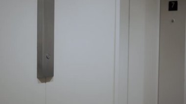Kapatın. Mans yukarı çıkmak için asansör düğmesine basar.