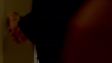 Siyah takım elbiseli bir işadamı binalara bakan büyük bir pencereye doğru yürüyor. Yavaş çekim görüntüleri