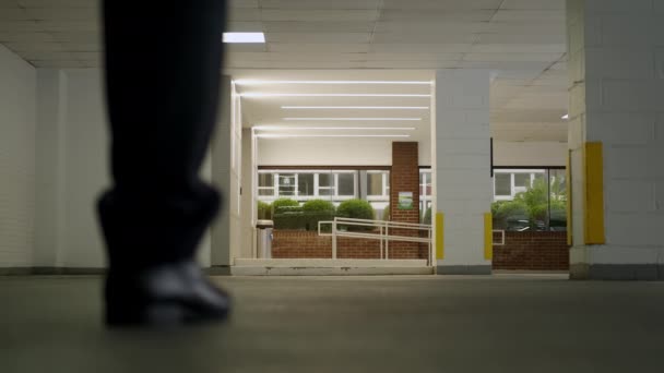 Un uomo d'affari vestito di nero cammina nel parcheggio. Da vicino. — Video Stock