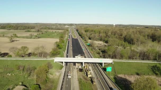 Luchtfoto drone uitzicht op de weg in de natuur. snelweg met auto 's omgeven door groene velden en bossen. — Stockvideo