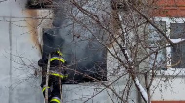 İtfaiyecinin biri caddedeki yıkık dökük bir evin enkazını spreyliyor.. 