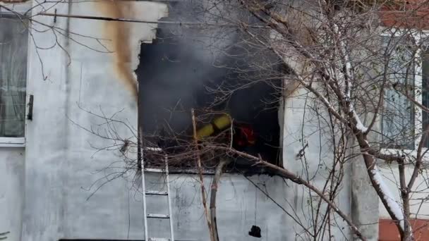 Ένας πυροσβέστης ψεκάζει τα φλεγόμενα ερείπια ενός κατεδαφισμένου σπιτιού στην οδό.. — Αρχείο Βίντεο