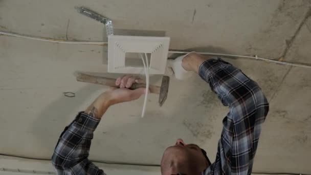 Built in lamp for false ceilings. The worker installs the mounting for the LED lamp which will be placed on the suspended ceiling — Stockvideo