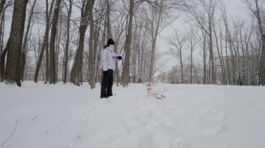 Parkta köpekli mutlu kız, Winter. Kar yağıyor. Kamerayı taşı