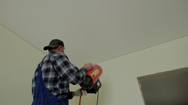 Close up footage of Workers stretch the stretch ceiling , heats the ceiling with a special device — Stockvideo