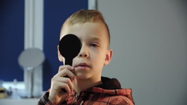 Νεαρό αγόρι στη ρεσεψιόν ενός οφθαλμίατρου, ελέγχει την όραση — Αρχείο Βίντεο