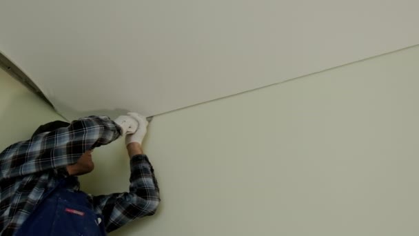 Close up view footage of Workers stretch the stretch ceiling in the room — Wideo stockowe