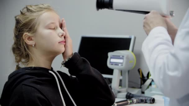 A young girl at the reception of an ophthalmologist, checks eyesight with a professional device. Close up — Video Stock