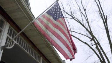 Rüzgarlı bir günde ön verandadaki Amerikan Bayrağının yakın görüntüsü.