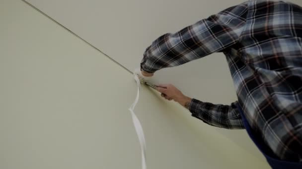 Close up view of Workers stretch the stretch ceiling in the room. — Stockvideo