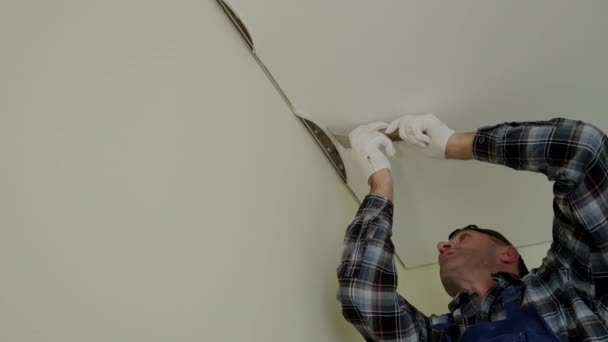 Primer plano de imágenes de los trabajadores estiran el techo tensado en la habitación — Vídeos de Stock
