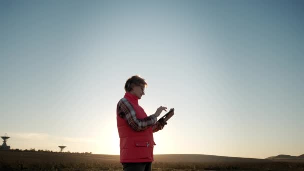 Wide shot footage of Farmer woman working with tablet in field analyzes quality of crop before harvesting. — Vídeo de Stock