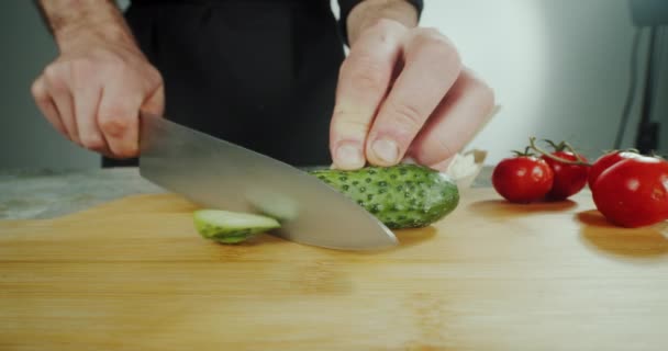 Close view Chef man cutting fresh cucumber. slicing cucumber in kitchen with sharp knife. — стоковое видео