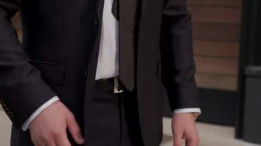 Close up unrecognizable man in suit looking at wrist watch checking time outdoors.