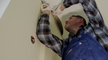 Close up footage of Workers stretch the stretch ceiling in the room. Down view