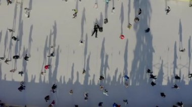 Aerial drone view of people skating on an outdoor skating rink in winter in City