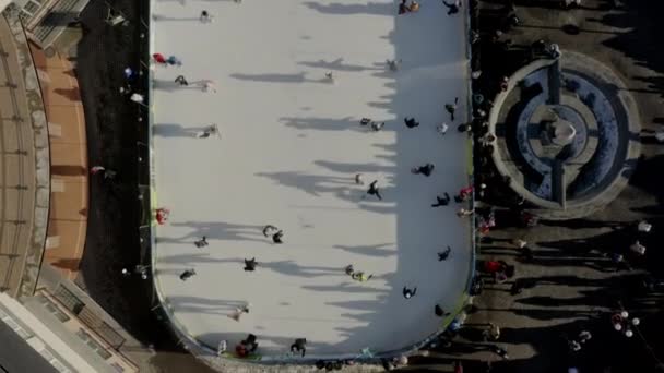 İnsansız hava aracının üzerinde, şehirde kış aylarında buz pateni pistinde paten kayan insanlar görülüyor. — Stok video
