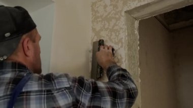Close up view of Worker puts decorative plaster on the wall, forming a relief 