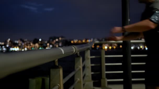 Un jeune sportif masculin au corps athlétique court la nuit sur la jetée près du voilier. Gros plan — Video