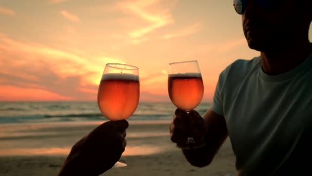 Κλείσε. Το ζευγάρι παίρνει δύο ποτήρια στα χέρια του με κρασί με θέα το ηλιοβασίλεμα στη θάλασσα. αργή κίνηση — Αρχείο Βίντεο