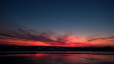 Mutlu çocuk gün batımında sahilde koşuyor.