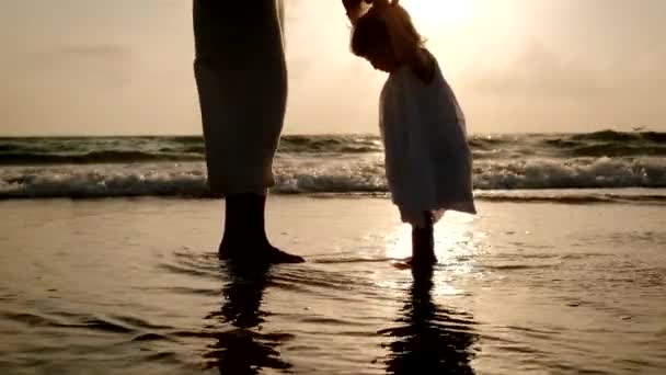 Moeder en dochter spelen samen op het strand bij zonsondergang, Close up — Stockvideo