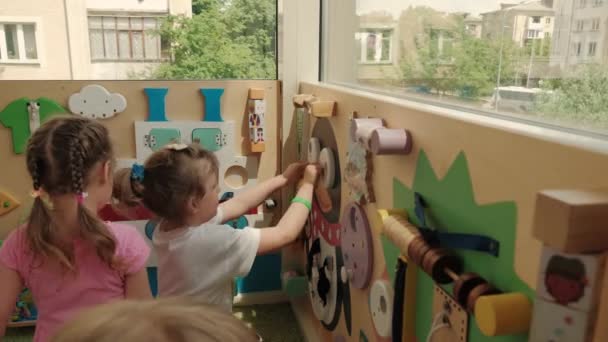 Lviv, Ukraina 12.06.2021 Schattig klein meisje die plezier hebben om te spelen glijbaan in plastic droog zwembad met kleurrijke ballen 4k — Stockvideo