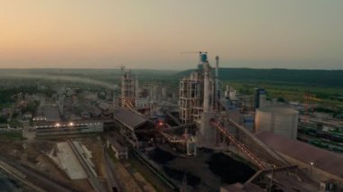 Geceleri endüstriyel üretim alanında yüksek fabrika yapısına sahip çimento fabrikasının havadan görünüşü ışıklar açıkken..