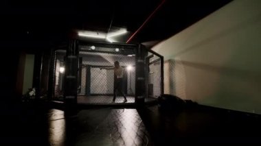 Anne dövüşçüsü spor salonunda kickboksla antrenman yapıyor.