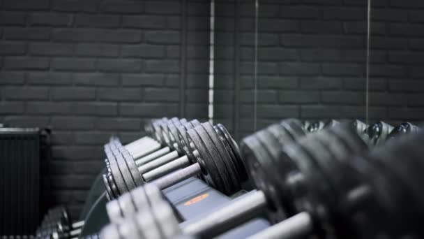 Hombre atlético en el gimnasio toma pesas antes de realizar el ejercicio — Vídeos de Stock