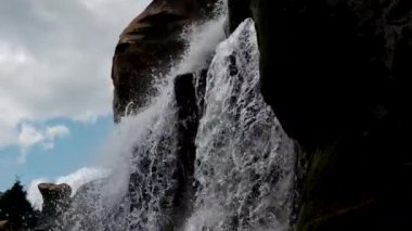 Güneşli bir günde dağlarda büyük bir şelale. Yavaş çekim görüntüleri