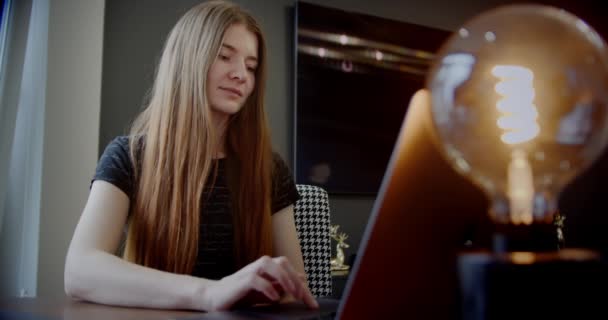 Jonge vrouw typen op laptop notebook toetsenbord zitten thuis kantoor bureau werken online. — Stockvideo