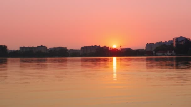 See und Natur im Hintergrund der Stadt bei Sonnenuntergang. Farben der Morgensonne. — Stockvideo