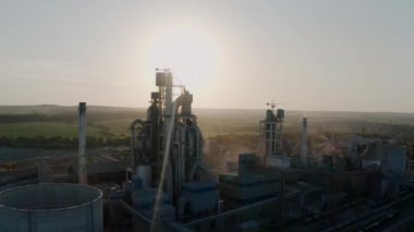 Gün batımında endüstriyel üretim alanında yüksek fabrika yapısına sahip çimento fabrikası. Hava görüntüleri