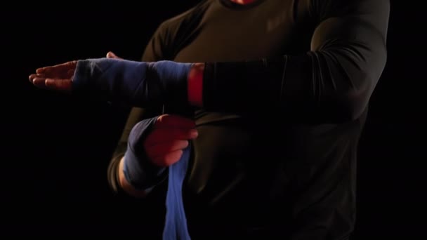 Mma combattente uomo avvolgendo le mani in nastro boxe prima di un combattimento vista da vicino — Video Stock