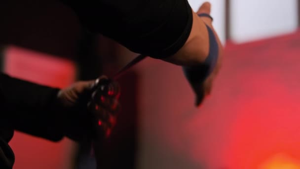 Крупним планом дивитися кадри бійця мам, який обмотує руки в боксерській стрічці перед поєдинком — стокове відео