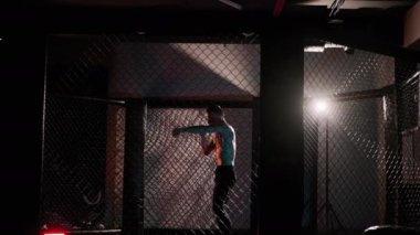 Dövüş sanatları dövüşçüsü spor salonunda kickboksla antrenman yapıyor. Yavaş çekim