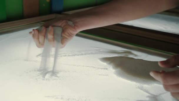 Närbild av kvinnors händer plocka upp sand i handflatorna och spiller korn av sand genom fingrarna. — Stockvideo