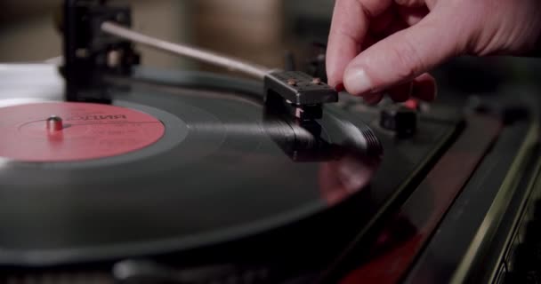 Hand turns on a vintage vinyl record and vinyl record is spinning. Cose up — Stock Video