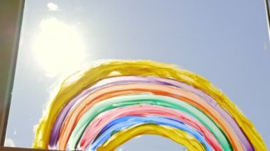 Gökkuşağı ev penceresinde. Güneşli bir günde, Coronavirus önleme kampanyası için sosyal medya kampanyasında evde kalın.