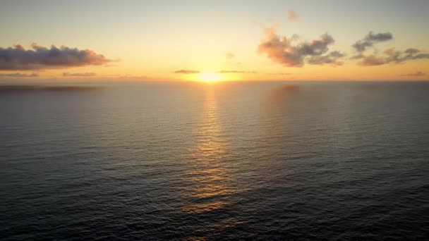 Беспилотник наблюдает закат над морем, океанские волны бьются на пляже — стоковое видео