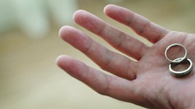 Damat alyansları elinde tutuyor, yakın çekim.