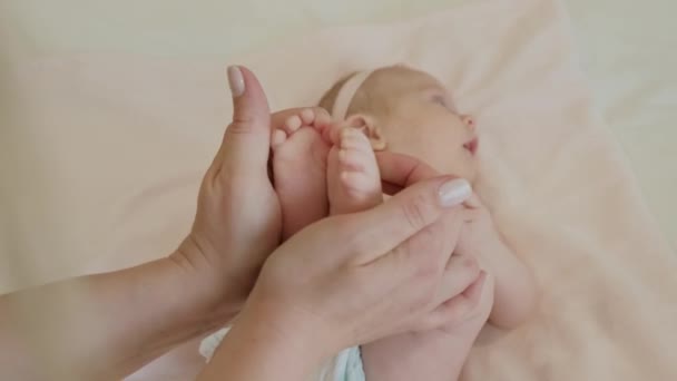 Nahaufnahme von Mutter, die mit Babyfüßen spielt. — Stockvideo